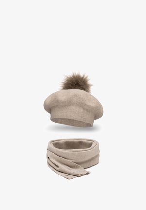 Berretto beige lavorato a maglia con un pompon in pelliccia sintetica sulla sommità, abbinato a una sciarpa beige coordinata in design a loop. Tessuto morbido e finitura liscia.