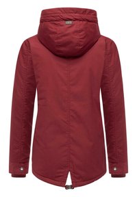 Röd jacka med lång ärm och huva, med en mjuk yta och justerbara ärmslut. Utmärkande ryggventil och logotags nära kragen.