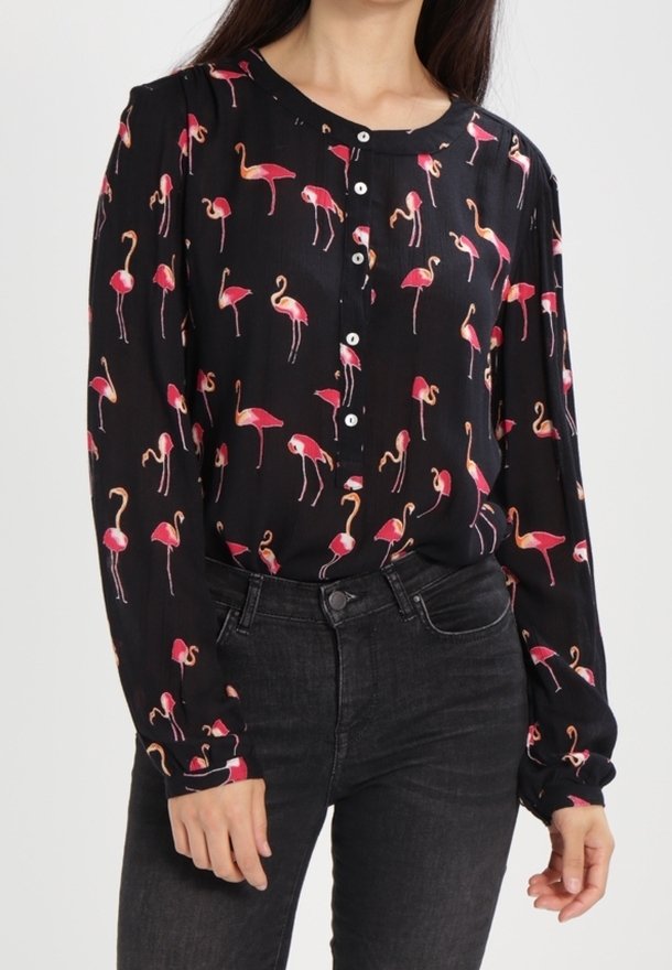 Schwarze Bluse mit einem Flamingo-Muster in Pink und Weiß. Verfügt über Knöpfe vorne und lange Ärmel mit gerafften Manschetten.