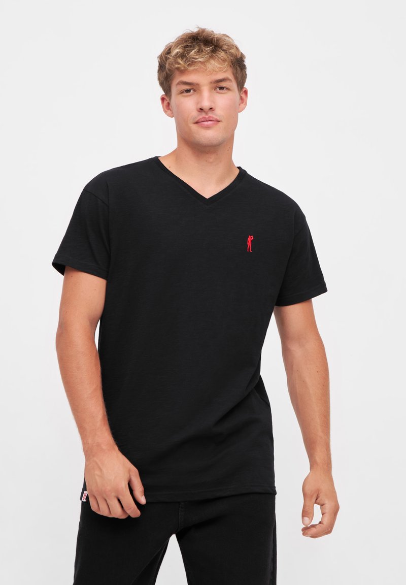 T-shirt noir à col en V fabriqué en matière douce, avec un petit logo rouge brodé sur la poitrine gauche, des manches courtes et une coupe décontractée.