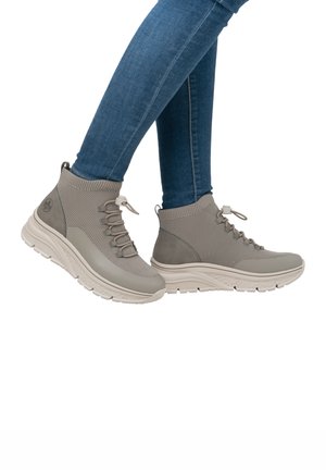 Gray high-top sneakers feature a knit upper, elastic laces, and a contrasting textured rubber sole. Accents include a logo on the side.