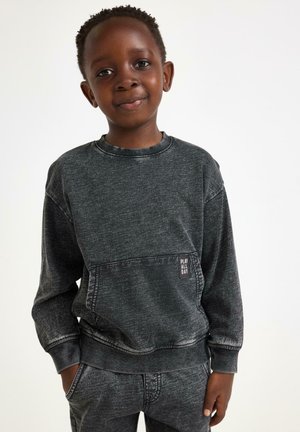 Sweatshirt en coton noir avec une finition texturée, des poignets côtelés et une poche avant portant une étiquette "JOUER TOUTE LA JOURNÉE".