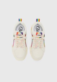 Zapatillas blancas con cordones de colores arcoíris, lengüetas traseras a juego y una suela texturizada. Logo en la lengüeta y detalle en el panel lateral.
