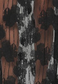 Material negru din dantelă cu modele florale, secțiuni transparente și dungi verticale. Textura este delicată, cu grosimi variate ale firelor.