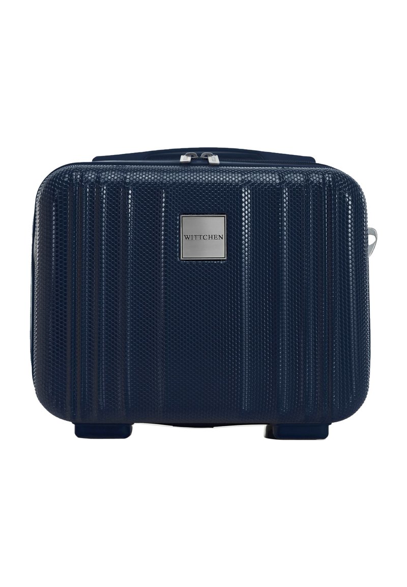 Marineblauwe harde koffers met een textuur, verticale ribbels, metalen logo-plaat en een rits aan de bovenkant. Compact rechthoekige vorm met vier voeten.