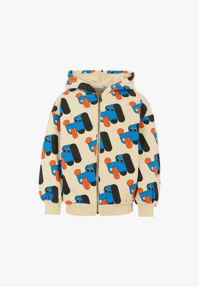 Felpa con zip beige caratterizzata da una stampa giocosa di cani a cartone animato blu e arancioni su tutta la superficie, con grandi accenti neri e occhi espressivi.