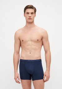 Tamno plave bokserice napravljene od mekanog materijala s fleksibilnim pojasom na kojem je logo Levi's. Jednostavan dizajn, bešavni prednji deo.
