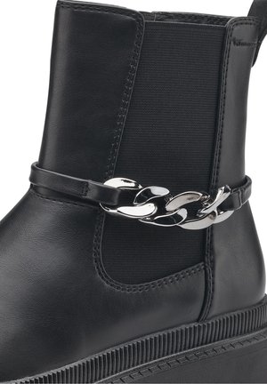 Bottine en cuir noir avec panneau élastique sur le côté et une bride décorative en chaîne argentée au-dessus d'une semelle épaisse à rainures.