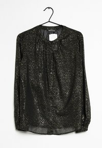 Blusa nera con scollo rotondo e maniche lunghe, decorata con macchie dorate, bottoni sul davanti e un tessuto trasparente.
