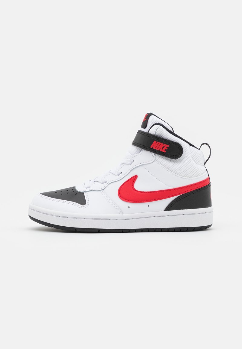 Baskets montantes Nike blanches, noires et rouges avec une sangle Velcro, logo swoosh rouge sur le côté et semelle noire sur fond blanc.