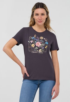 T-shirt grigio scuro realizzato in morbido cotone, con un design grafico floreale in vari colori e il testo "Scegli di Fiorire" sotto.