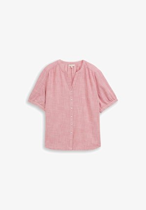 Roze blouse met korte mouwen, voorzien van kleine witte knoopjes aan de voorkant en een ronde hals met een korte V-vormige uitsnijding.