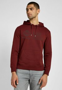 Bordowa bluza z kapturem wykonana z miękkiego materiału; posiada kieszeń kangurzą, regulowane sznurki oraz nadruk logo z przodu.