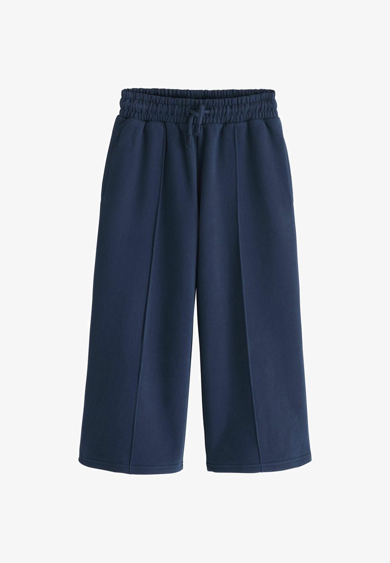 Pantalon large court bleu marine avec taille élastique et cordon de serrage, doté de poches latérales et de détails de coutures sur le devant.