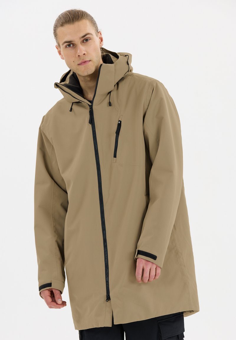 Beige wasserdichte Jacke mit Kapuze, schwarzen Reißverschlüssen und Akzenten, langen Ärmeln und mittellanger Schnittführung. Verfügt über eine Brusttasche und verstellbare Kordelzüge.