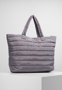 Padded gray tote bag with horizontal stitching and two short handles, displayed on a white surface against a plain background.