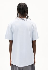 Lichtblauwe katoenen t-shirt met korte mouwen en een comfortabele pasvorm, met een gladde textuur en een ronde halslijn, gezien vanaf de achterkant.