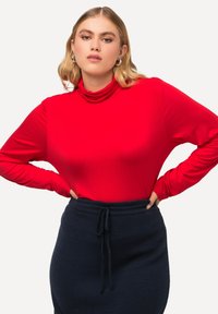 Rode turtleneck top met lange mouwen van een gladde, rekbare stof, gecombineerd met een donkerblauwe rok met koordjes, met een relaxte pasvorm.