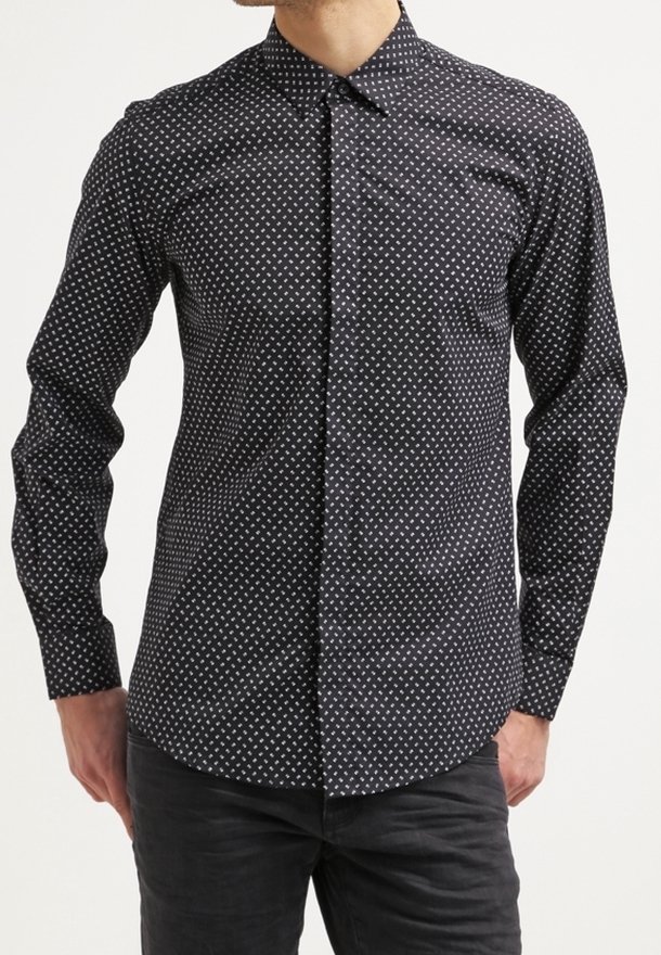 Camicia nera con bottoni, caratterizzata da un sottile motivo a rombi bianchi. Presenta un colletto classico e maniche lunghe con orlo dritto. Materiale in misto cotone.