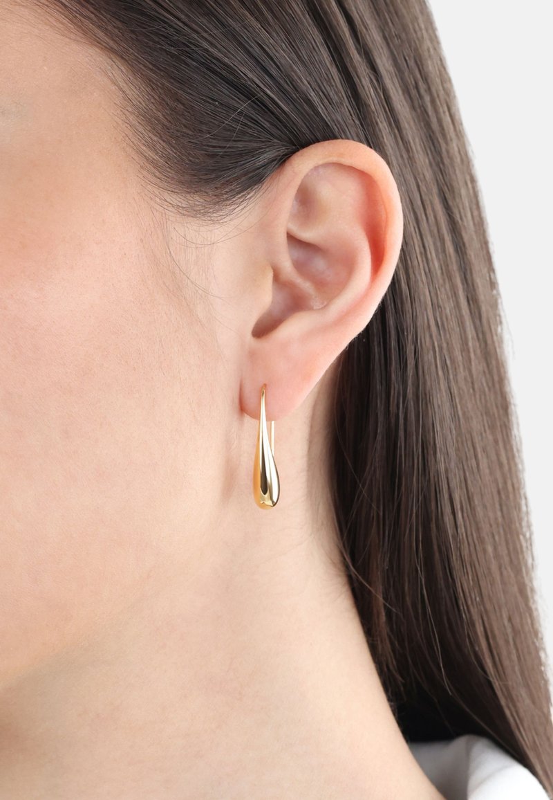 Orecchini a goccia in oro con una finitura lucida. Il design presenta una forma slanciata ed allungata che si restringe a punta.