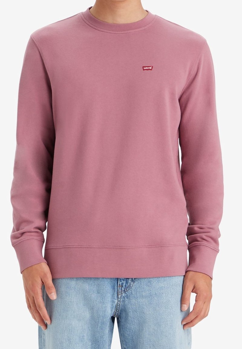 Crewneck sweatshirt i ljusrosa, tillverkad av mjukt material. Har långa ärmar och en liten röd Levi's-logotyp på bröstet. Lätt och avslappnad passform.