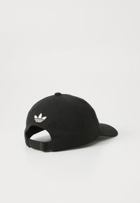Sort baseball cap lavet af bomuld, med en buet skygge og et broderet hvidt trefoil-logo på bagsiden. Justerbar remlukning.