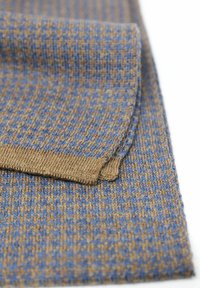 Écharpe en tissu tricoté avec un motif texturé dans des nuances de marron et de bleu. Les bords présentent une finition côtelée marron uni pour plus de structure.
