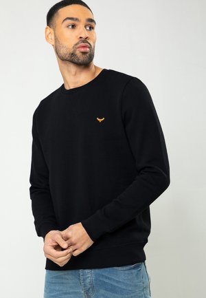 Schwarzer Baumwollpullover mit Rundhalsausschnitt, ausgestattet mit einem orangefarbenen Logo auf der Brust sowie gerippten Bündchen und Saum.