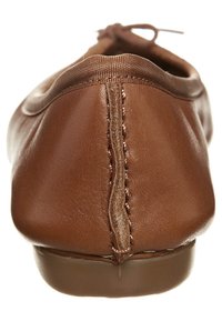 Bruine leren balletschoenen met een afgeronde achterkant, een zachte textuur en een dunne gestikte naad. Voorzien van een flexibele zool en een stoffen strikdetail.