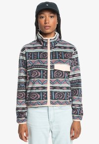 Fleece jacket featuring a geometric pattern in pink, blue, and black, with a high collar, full zipper, and a front chest pocket.