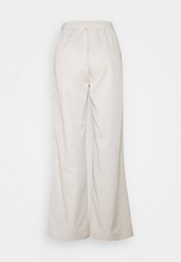 Beige loose-fit pants with an elastic waistband, front pockets, and wide straight legs.