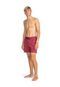 Pantaloni scurți de baie roșii, confecționați dintr-un material ușor, având un brâu elastic cu șnur negru și un mic patch cu logo pe tiv.