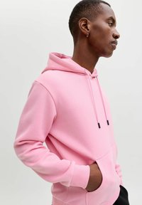 Felpa con cappuccio rosa in tessuto morbido, con tasca a marsupio, cappuccio con coulisse, polsini e orlo a costine.