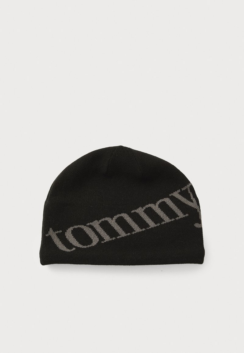 Sort strikket hue med rund top. Har et kontrastfarvet gråt 'tommy'-logo langs siden. Blød tekstur og tætsiddende design.