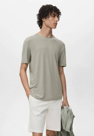 Heren t-shirt met korte mouwen in lichtgroen, zachte stof, ronde halslijn, gecombineerd met witte shorts. Eenvoudig ontwerp, casual pasvorm, geen patronen.