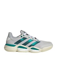 Chaussure de sport gris clair avec des bandes métalliques bleu sarcelle, lacets blancs et semelle rembourrée, conçue pour le sport ou un usage casual.