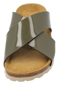 Grön patentsandaler med korsremmar, en korksula och en texturerad tan fotbädd. Designen är öppen tå med en slät finish på remmarna.