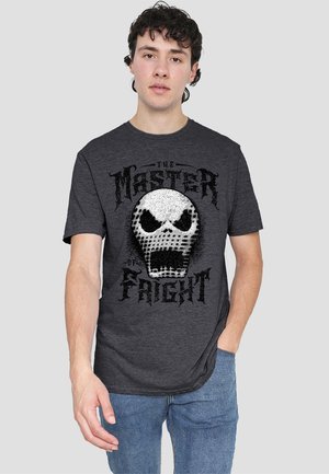 Graues T-Shirt mit einem zentralen Schädelmotiv und strukturierten Mustern. Das Design umfasst den Text "Der Meister des Schreckens" in fetter Schrift.