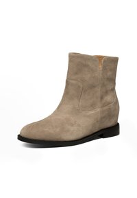 Beige mockasinkänga med rund tå, minimal sömsömnad och en platt svart sula. Lätt texturerad yta med låg klack.