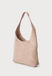 Sac à main en suède rose pâle avec une bandoulière incurvée. Présente une forme structurée et des détails de couture subtils sur le panneau avant.