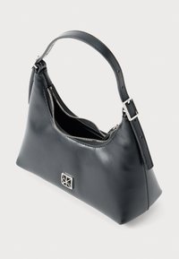 Borsa a tracolla in pelle nera con zip argentata, tracolla regolabile corta e emblema geometrico argento sul davanti, mostrata aperta su uno sfondo bianco.