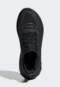 Pantofii sport negri au un toc texturat, un vârf întărit și un guler căptușit. Prezintă șireturi plate și o talpă cu profil redus pentru stabilitate.