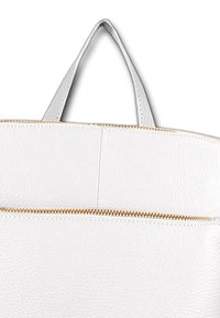 Witte leren tote bag met een textuurafwerking, voorzien van een ritssluiting aan de bovenkant en een lus handvat. Verfraaid met een gouden rits.