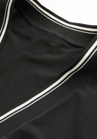 Abito nero con scollatura a V caratterizzato da una texture morbida. Il colletto ha un motivo a righe bianche e nere.