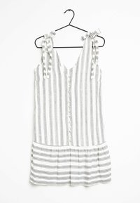 Vestido blanco con rayas verticales negras, escote en V, tirantes atados, frente con botones y un detalle de volantes en la parte inferior. Tejido ligero.