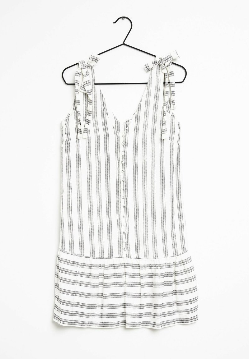 Vestido blanco con rayas verticales negras, escote en V, tirantes atados, frente con botones y un detalle de volantes en la parte inferior. Tejido ligero.