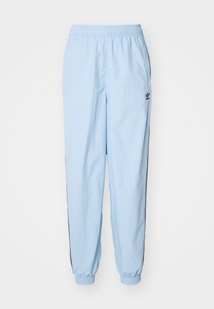 Pantaloni de jogging de culoare albastru deschis, fabricați dintr-un material moale, cu un brâu elastic, mansete și o dublă neagră pe lateral. Include un detaliu mic cu logo.