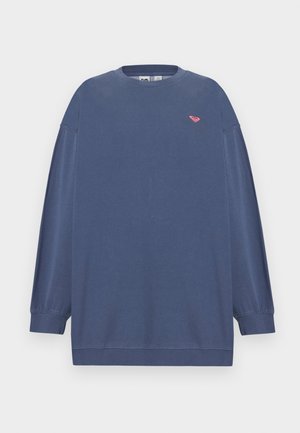 Kék hosszú ujjú, kerek nyakú pulóver bordázott mandzsettákkal és egy kis rózsaszín szív alakú logóval a bal mellrészen.