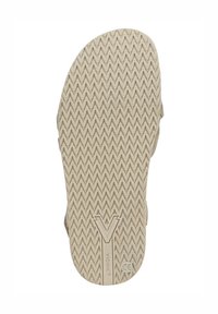 Rubberen schoenzool met een getextureerd zigzagpatroon; lichte beige kleur; heeft een logo en gladde randen voor slipweerstand.