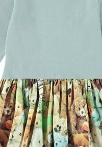 Ljusblå ribbad topp med en plisserad kjol som har en färgglad heltryck med nallebjörnar och mjukisdjur i olika färger.